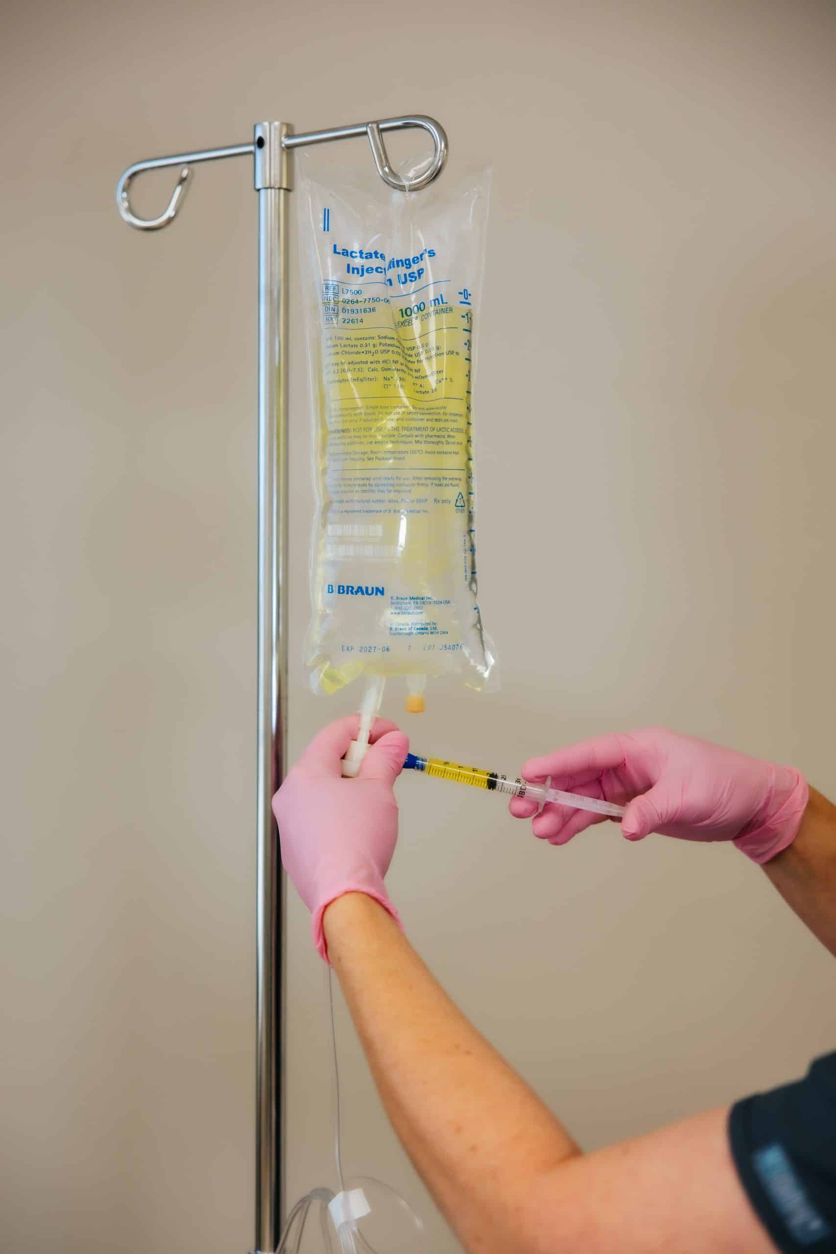 Registered nurse starting a mobile IV therapy drip in a Tooele, Utah home