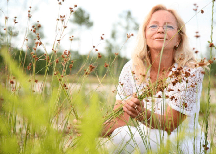 Blonde woman in grassy field